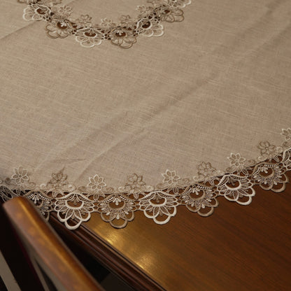 Edge of the round table sheet showing the floral lace border