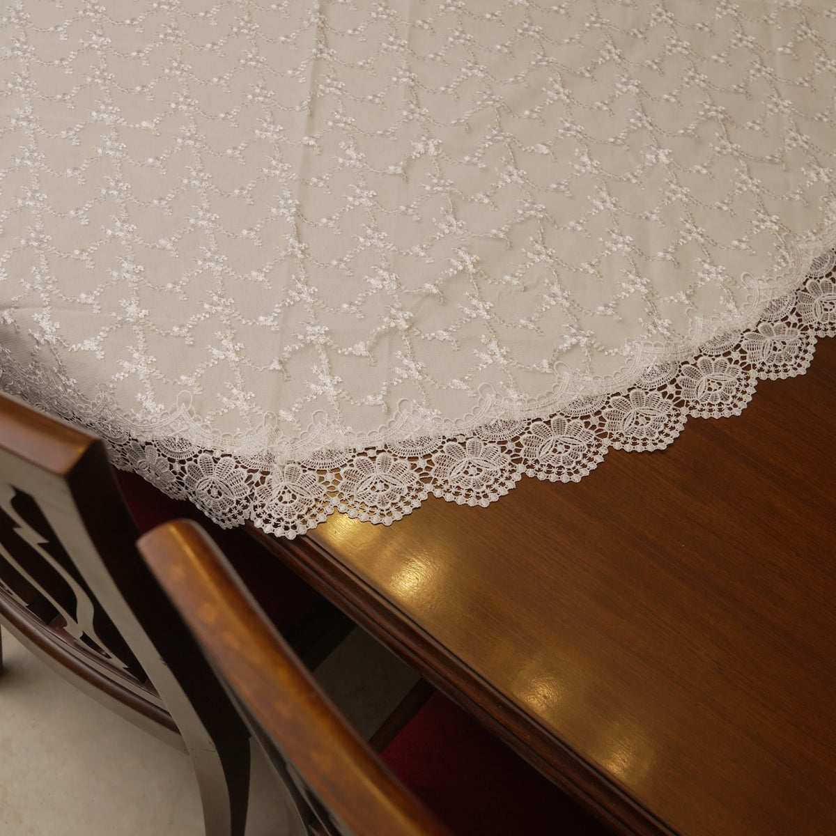 Edge of the round table sheet showing the scalloped embroidered border