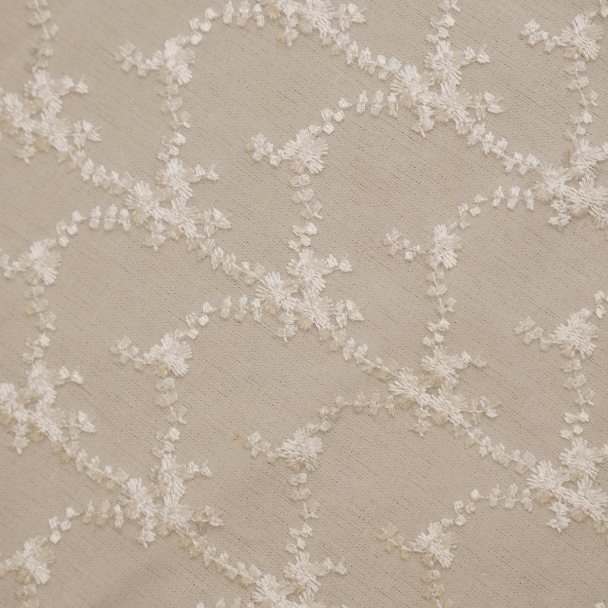 Close-up of the white floral vine embroidery