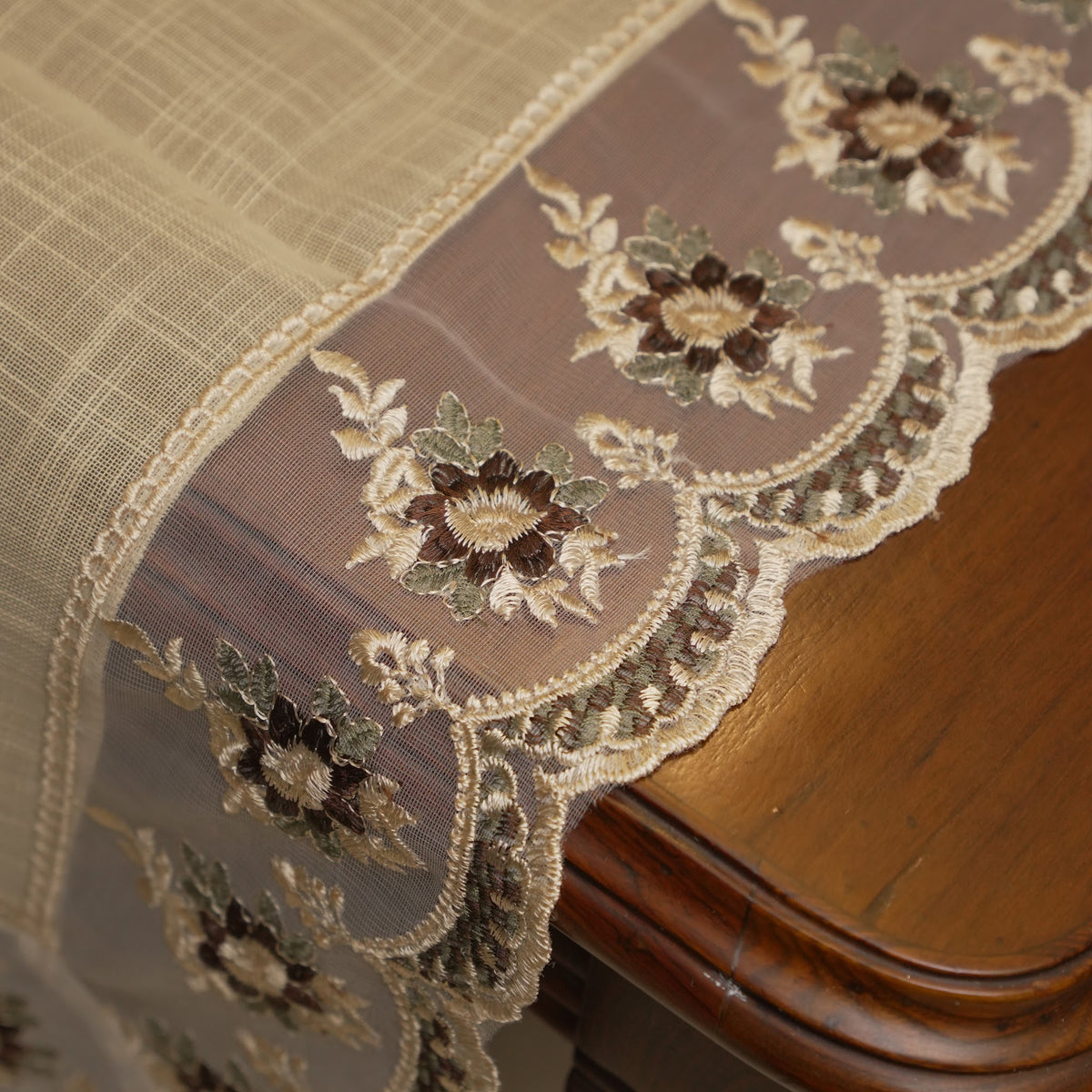 Sheer border with maroon floral embroidery at the table edge