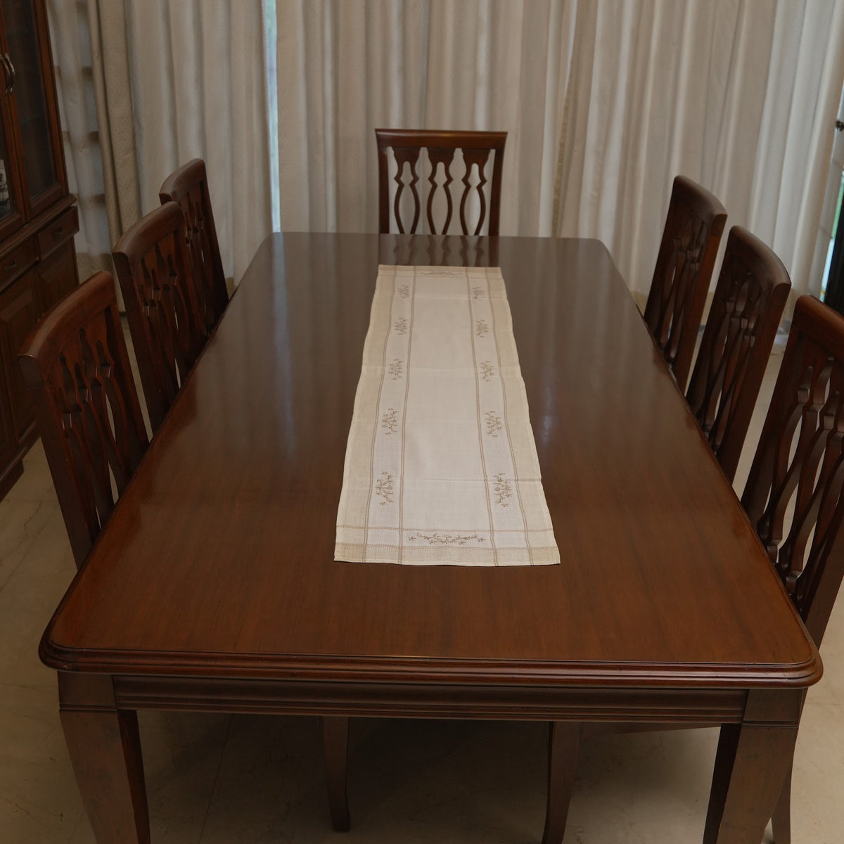 Cross-stitch floral linen runner on a dining table