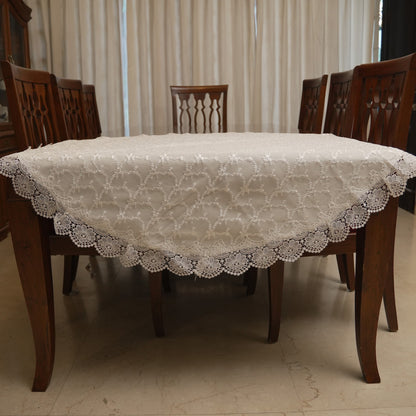 White floral embroidered round table sheet on a dining table