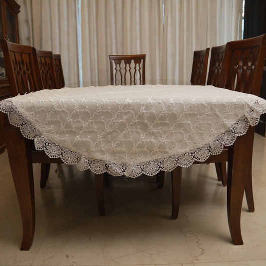 White floral embroidered round table sheet on a dining table