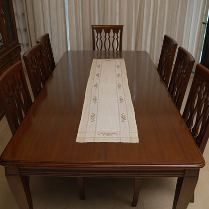 Olive cross-stitch linen runner on a dining table