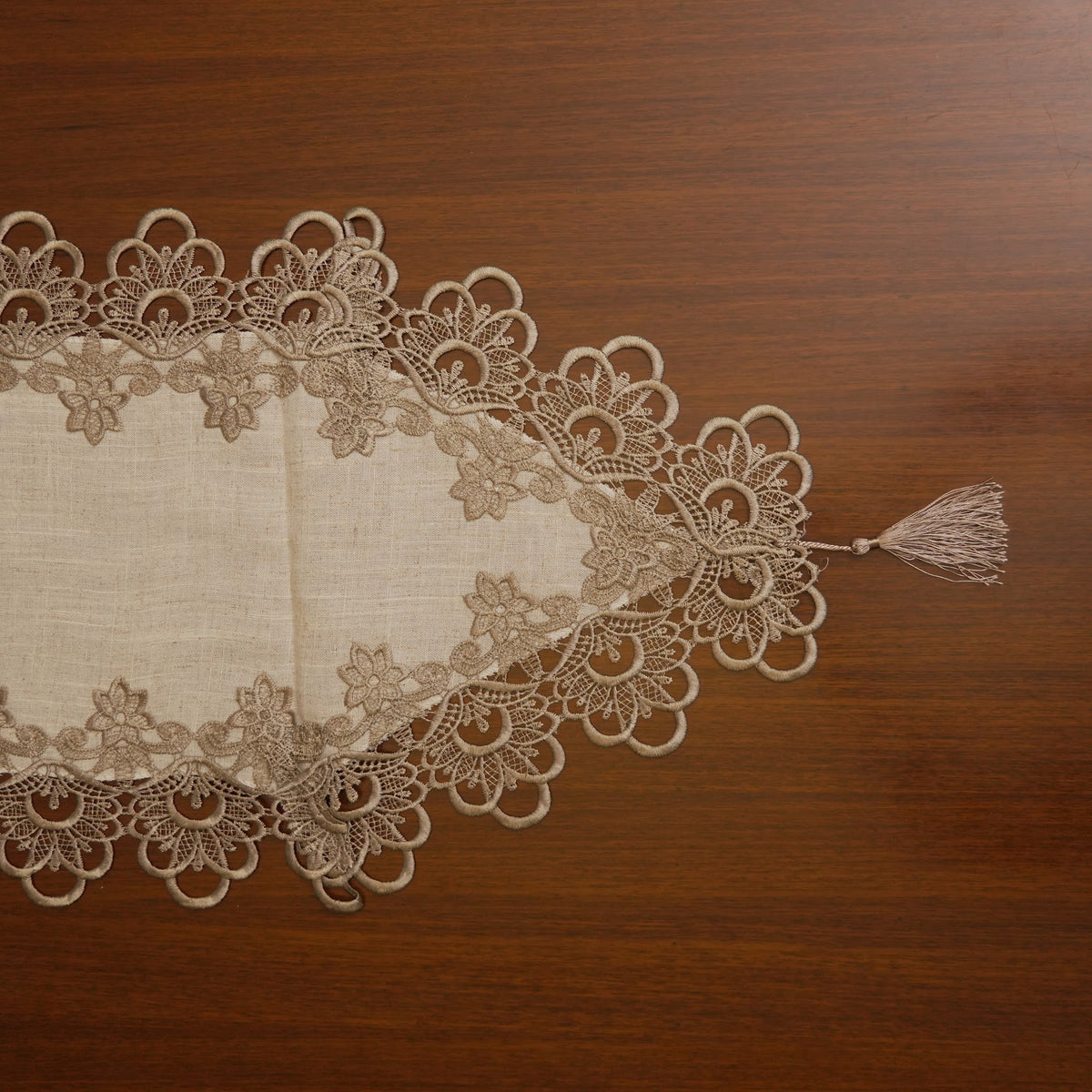 Pointed lace end of the runner with tassel