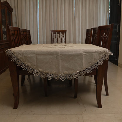Natural linen round table sheet with lace border on a dining table
