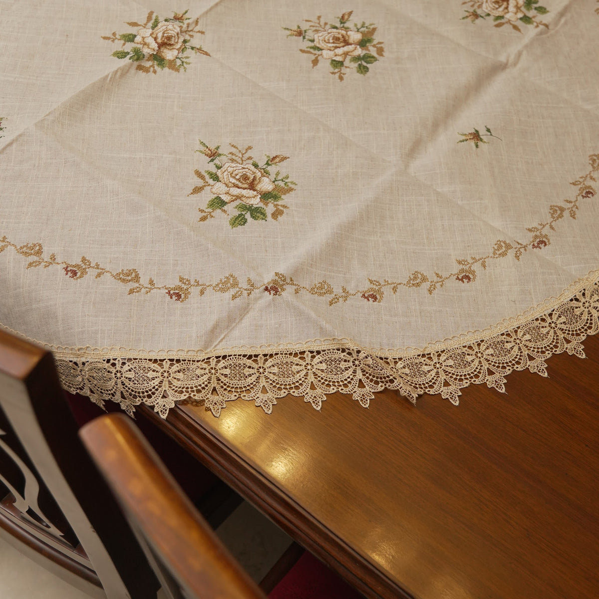 Edge of the round table sheet with embroidered roses and lace trim