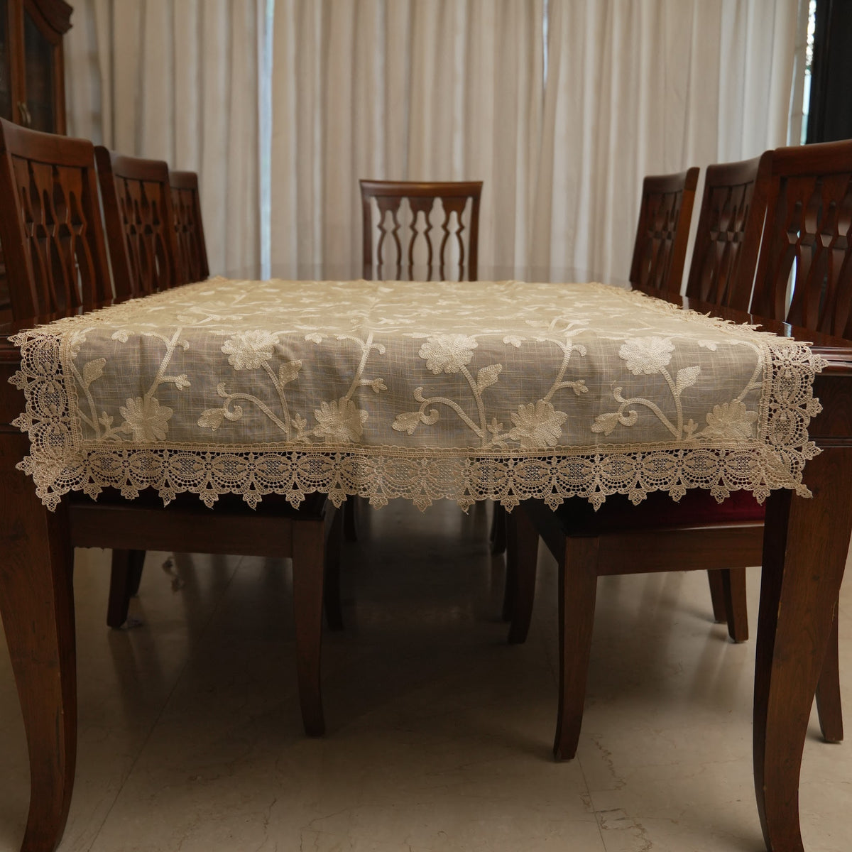 Cream floral embroidered table sheet on a dining table