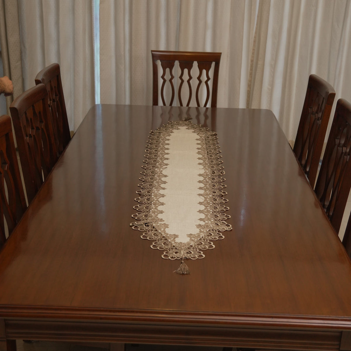 Taupe lace border linen runner on a dining table